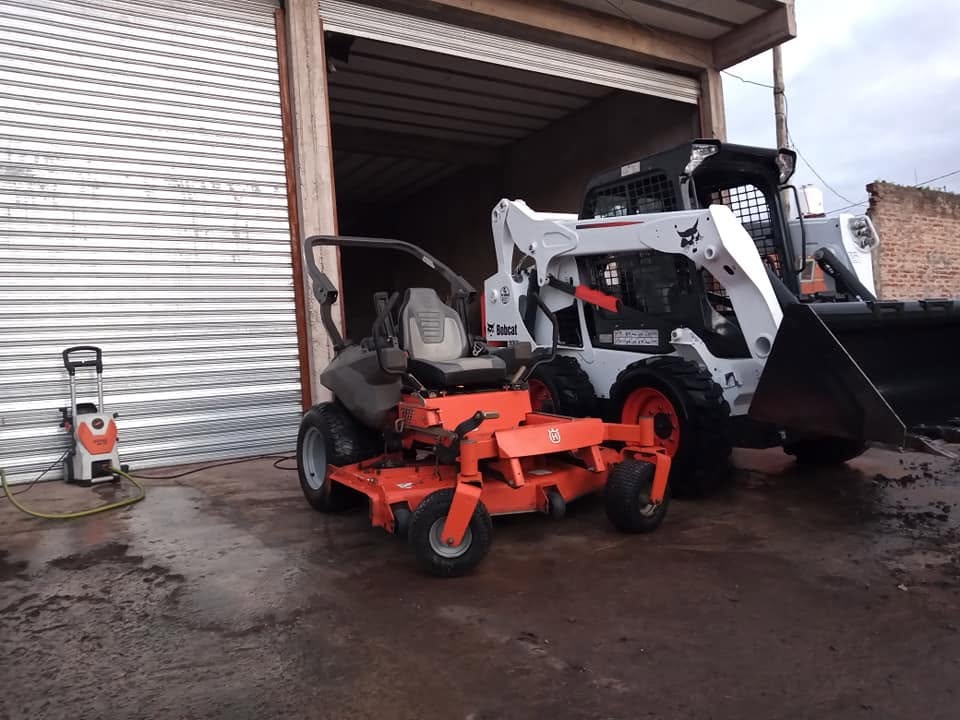Minicargadora Bobcat y equipos en el galpón