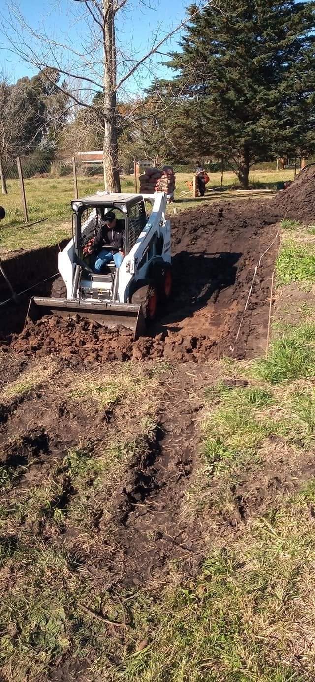 Minicargadora excavando zanja