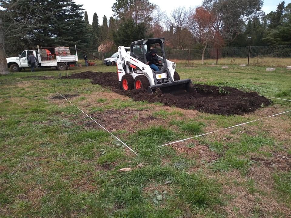 Minicargadora preparando terreno en un parque